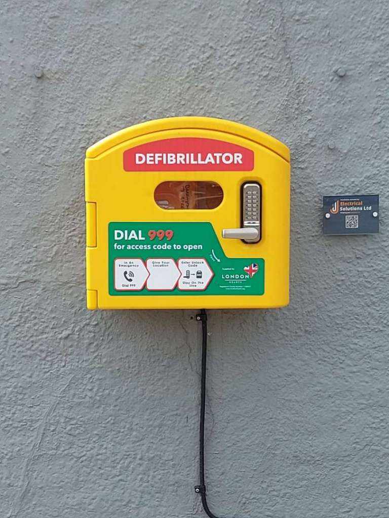 Image of the defibrillator on the wall of the Spread 2